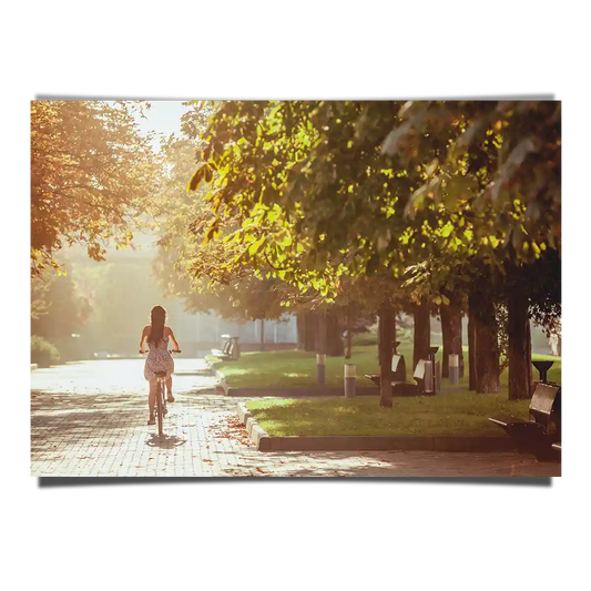 Girl Riding Bicycle at the Park with Trees in Morning Warm Sun